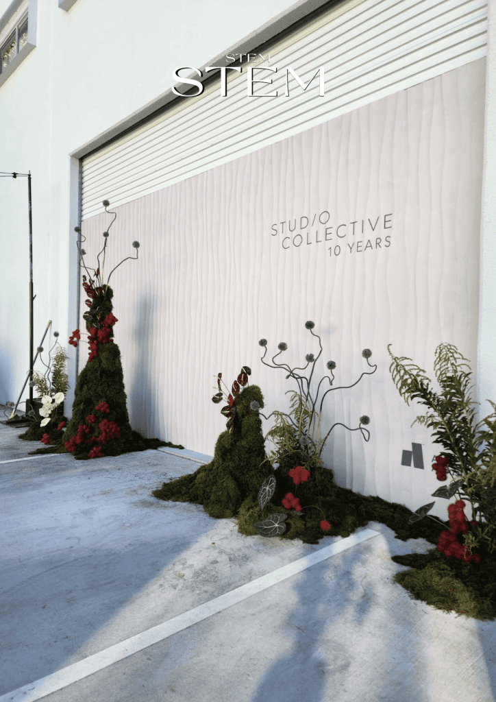 Structural floral installation by Stem Design for Studio Collective’s 10-year celebration, featuring moss bases, sculptural branches, and vibrant blooms.