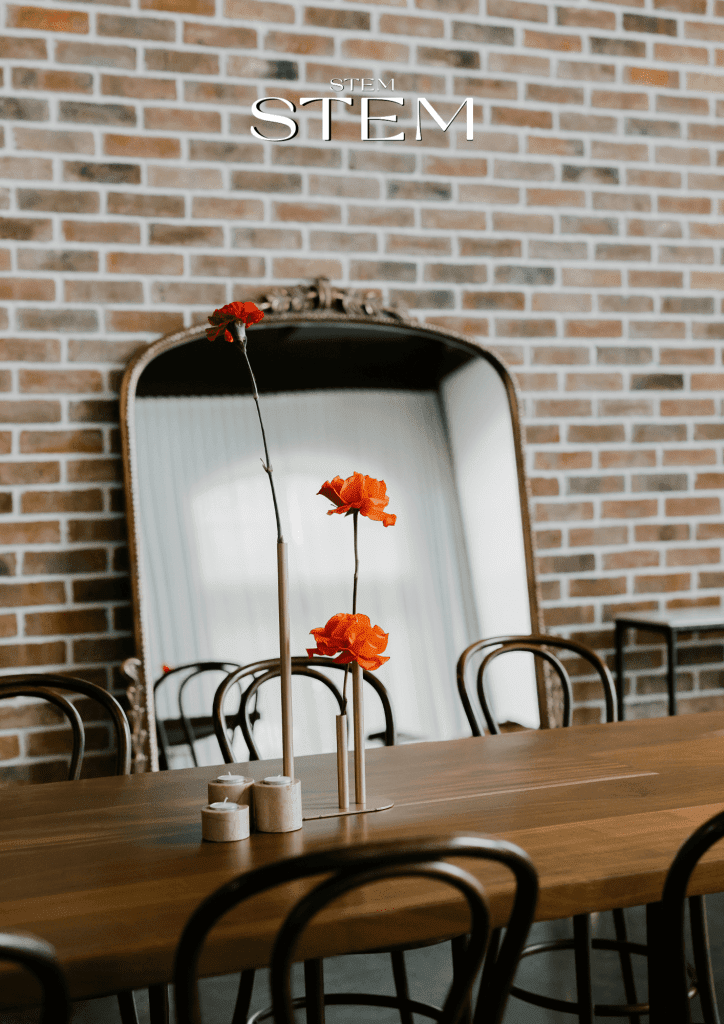 Minimal floral arrangement with red and orange flowers in slim gold vases styled by Stem Design, Brisbane wedding florist.