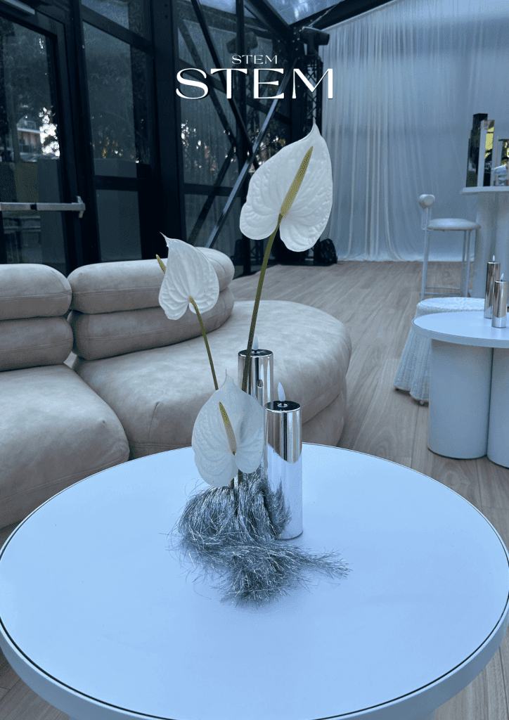 A minimalist floral arrangement featuring white anthuriums accented with rhinestones and reflective silver materials, styled by Stem Design at Glo House, a transparent event pavilion in Roma Street Parklands.