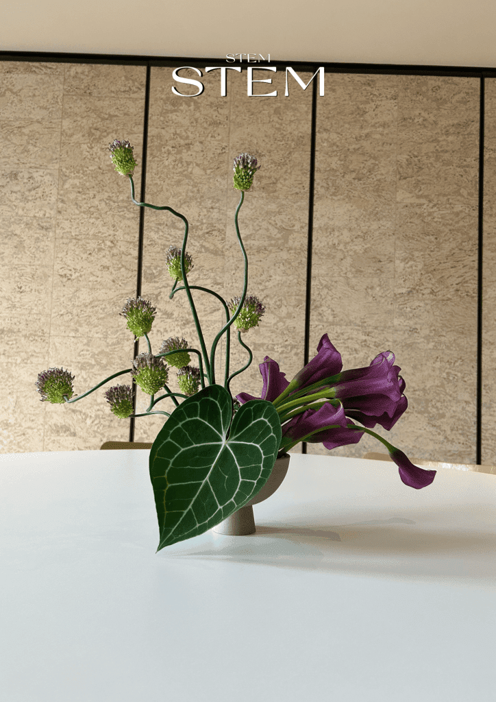 Minimalist floral arrangement featuring purple calla lilies, allium, and anthurium leaf styled by Stem Design Brisbane.