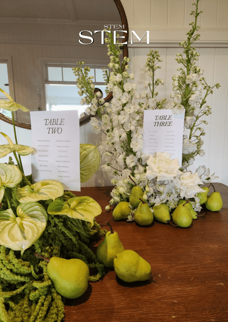 Modern wedding table styling with white delphiniums, roses, anthuriums, cascading amaranthus, and fresh pears designed by Stem Design in Brisbane.