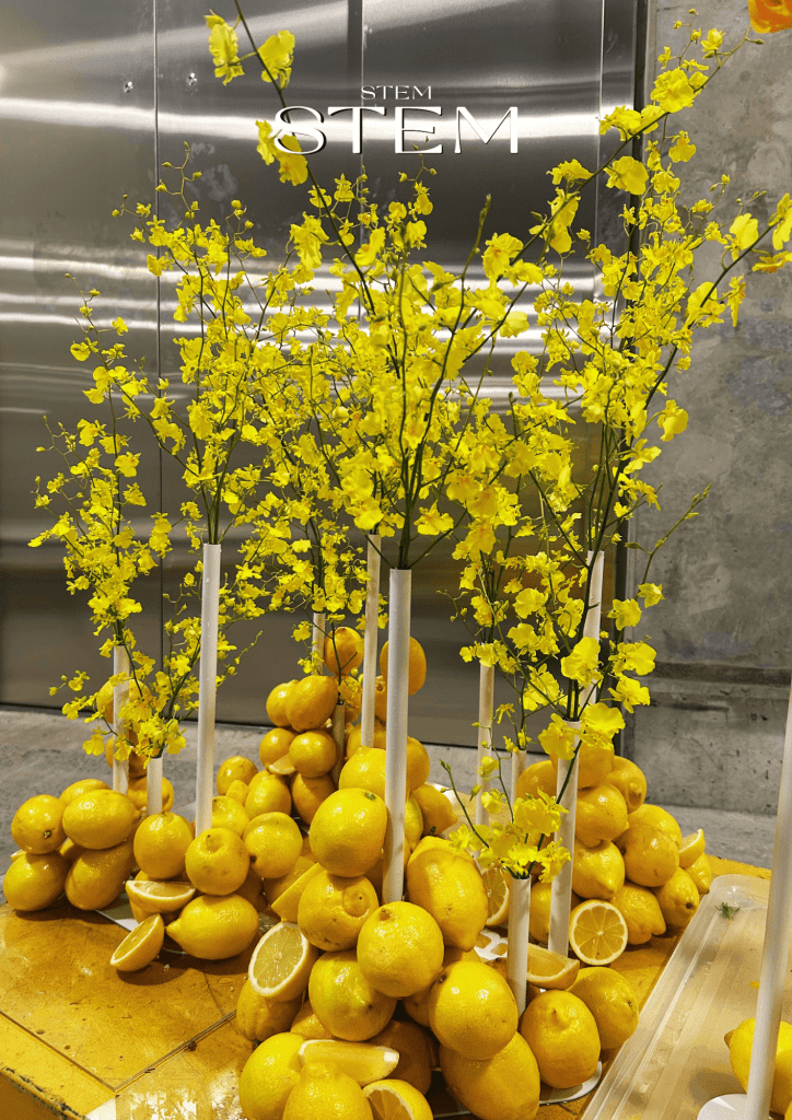 Bold yellow floral installation with orchids and fresh lemons styled by Stem Design for weddings and events in Brisbane.