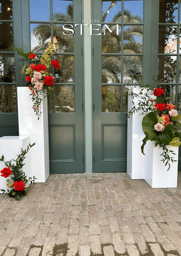 Modern entry floral arrangement featuring red roses, orchids, anthuriums, and tropical leaves by Stem Design Brisbane.