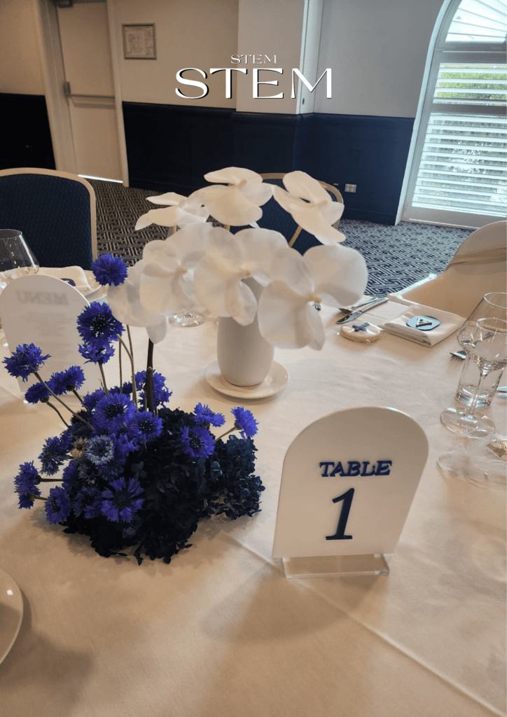 White orchids and blue cornflowers arranged by Stem Design for a christening event in Brisbane.