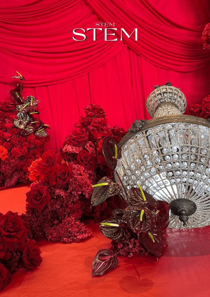 Luxury Christmas event floral installation featuring red roses, festive draping and statement florals by Stem Design for a corporate event.