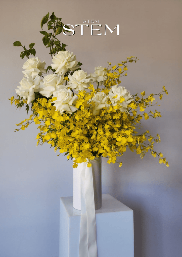 Elegant wedding flowers and event flowers featuring white roses and yellow orchids styled by Stem Design for weddings and corporate events.