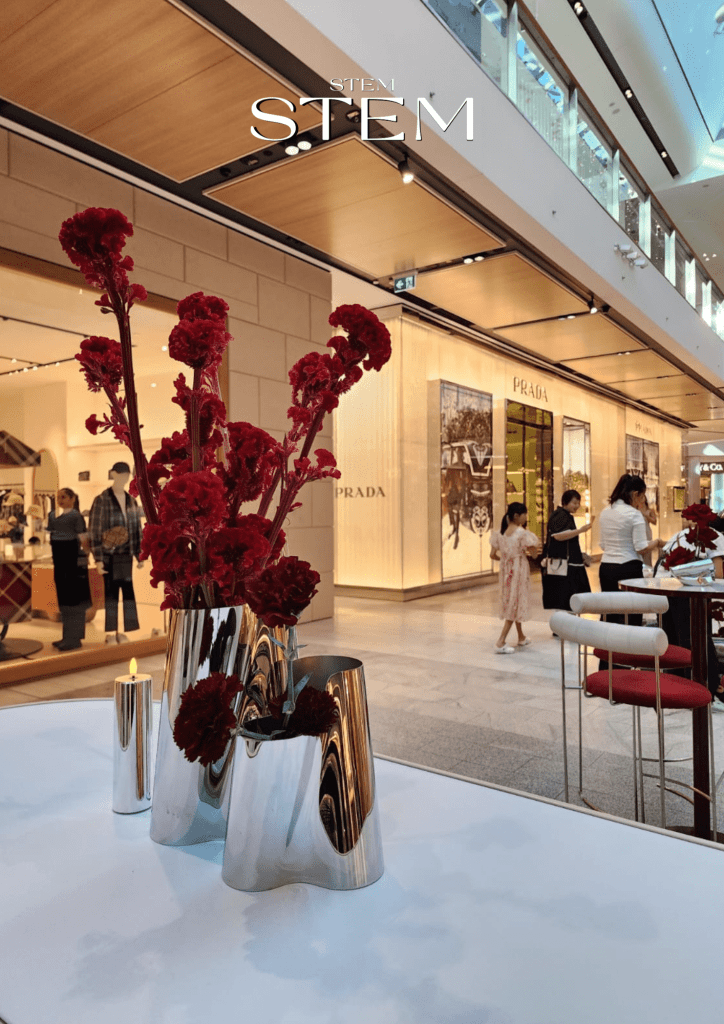 Luxury red floral arrangement in polished silver vases styled by a florist for high fashion events at a premium retail brand activation.