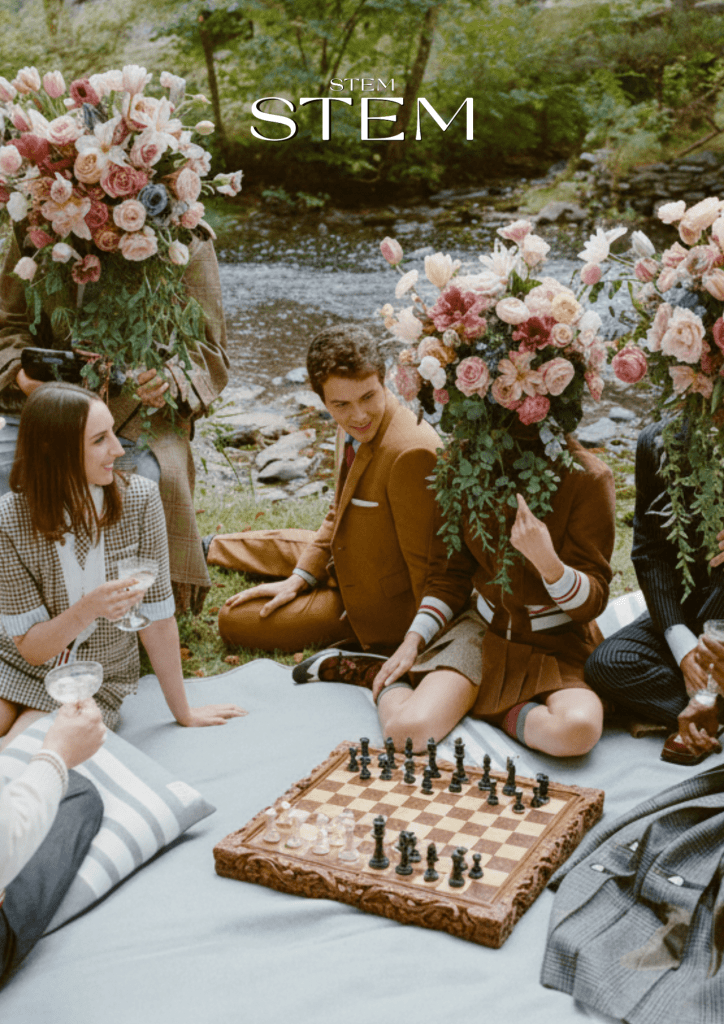 Outdoor wedding and event flowers featuring red roses, orchids and grapes styled on a garden drinks table by Stem Design
