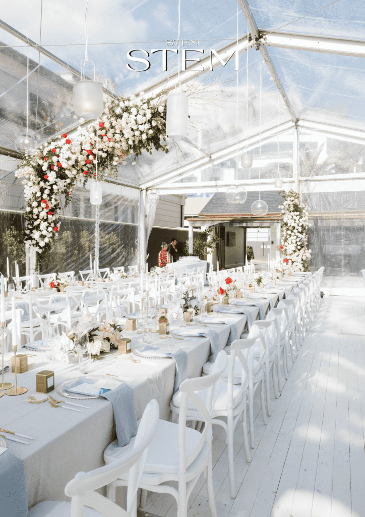 Outdoor wedding reception styled with fresh wedding flowers by a Brisbane wedding florist under a clear marquee